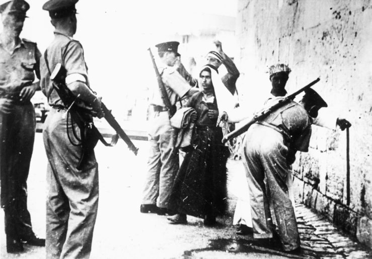 1936至 1939 年的阿拉伯人叛變讓英軍進入警戒狀態。照片是英國士兵於耶路撒冷在巴勒斯坦人身上搜尋槍械。