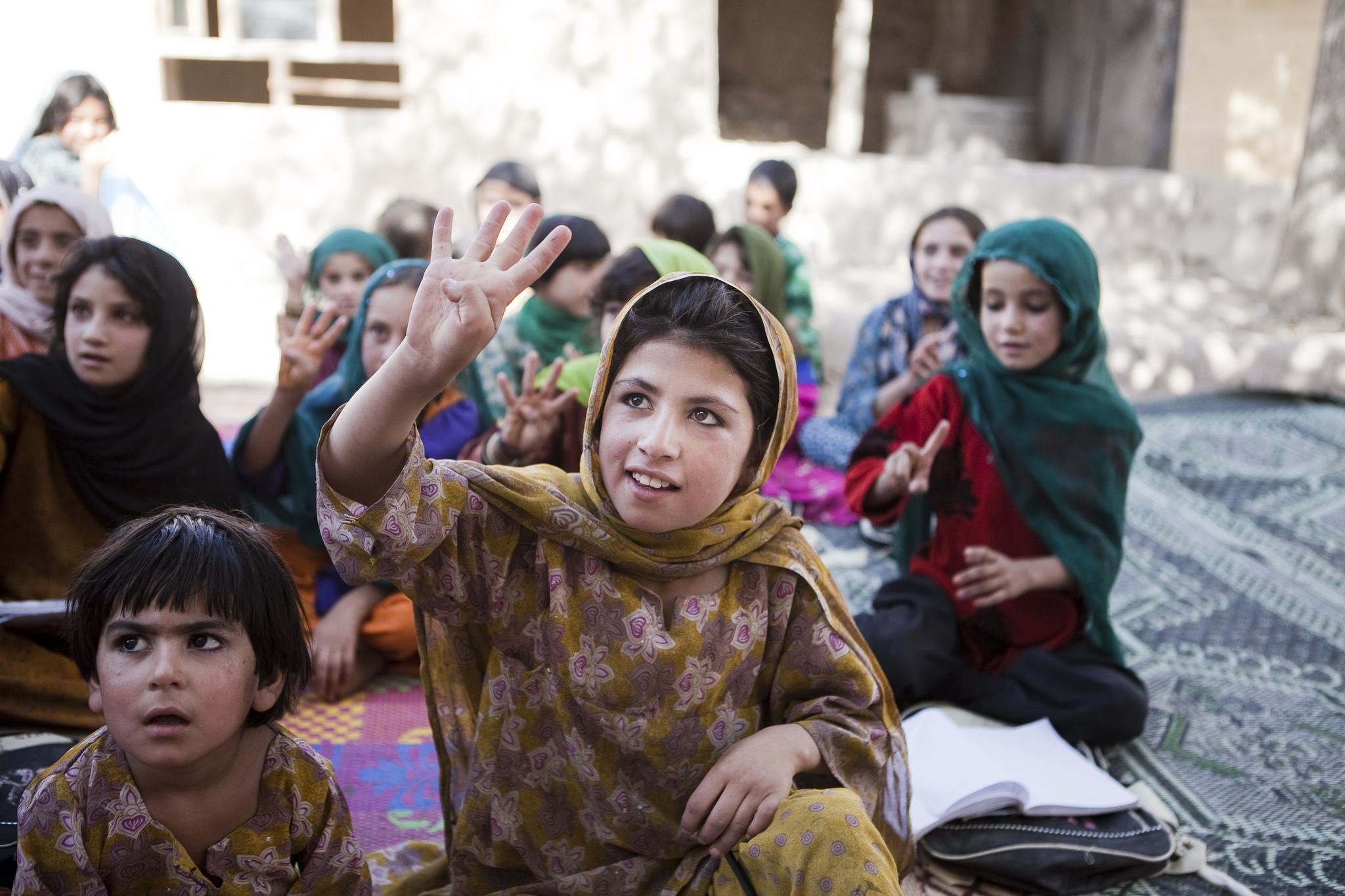 Khalida raises her hand to anwer a question in the Puti Kalatsha community-based education class